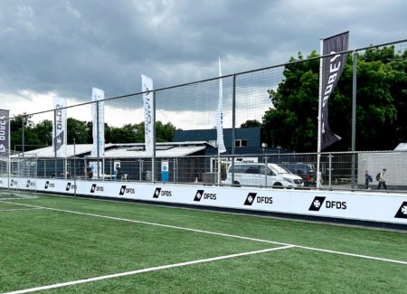 Baniervlaggen met DFDS-logo wapperend langs het veld bij De Bezelhorst