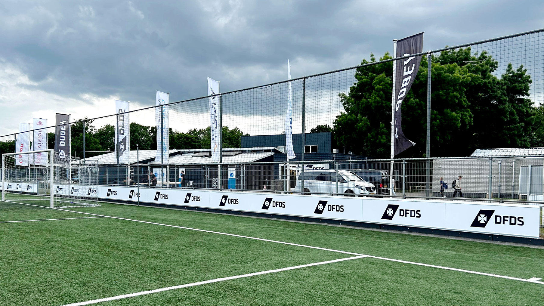 Baniervlaggen met DFDS-logo wapperend langs het veld bij De Bezelhorst