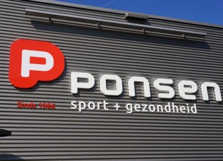 Grote tweekleurige Acrylox gevelletters 'Ponsen Sport & Gezondheid' geplaatst door Mull2media op de damwandgevel in Dinxperlo.